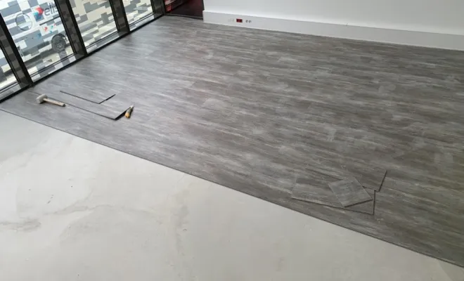 Pose des lames PVC en cours, après séchage du ragréage.