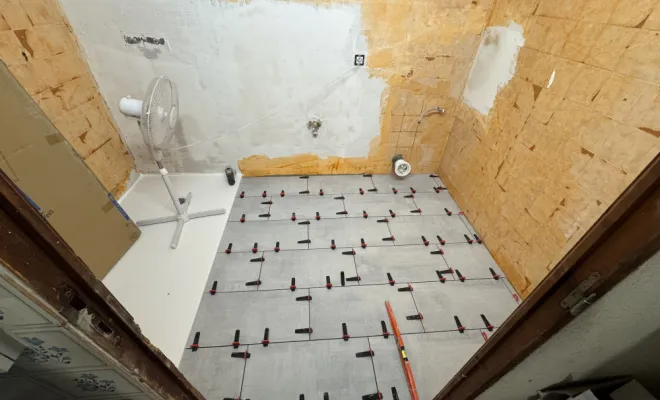 Après le surfaçage de la faïence et du carrelage, pose du bac à douche extra-plat et du nouveau carrelage